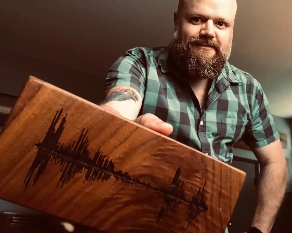Mike LaTour holding Soundwave Art wood artwork