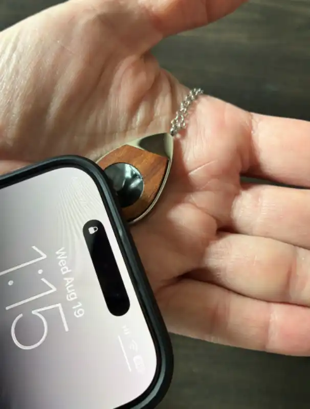 Phone tapping the back of a playable Soundwave Art necklace